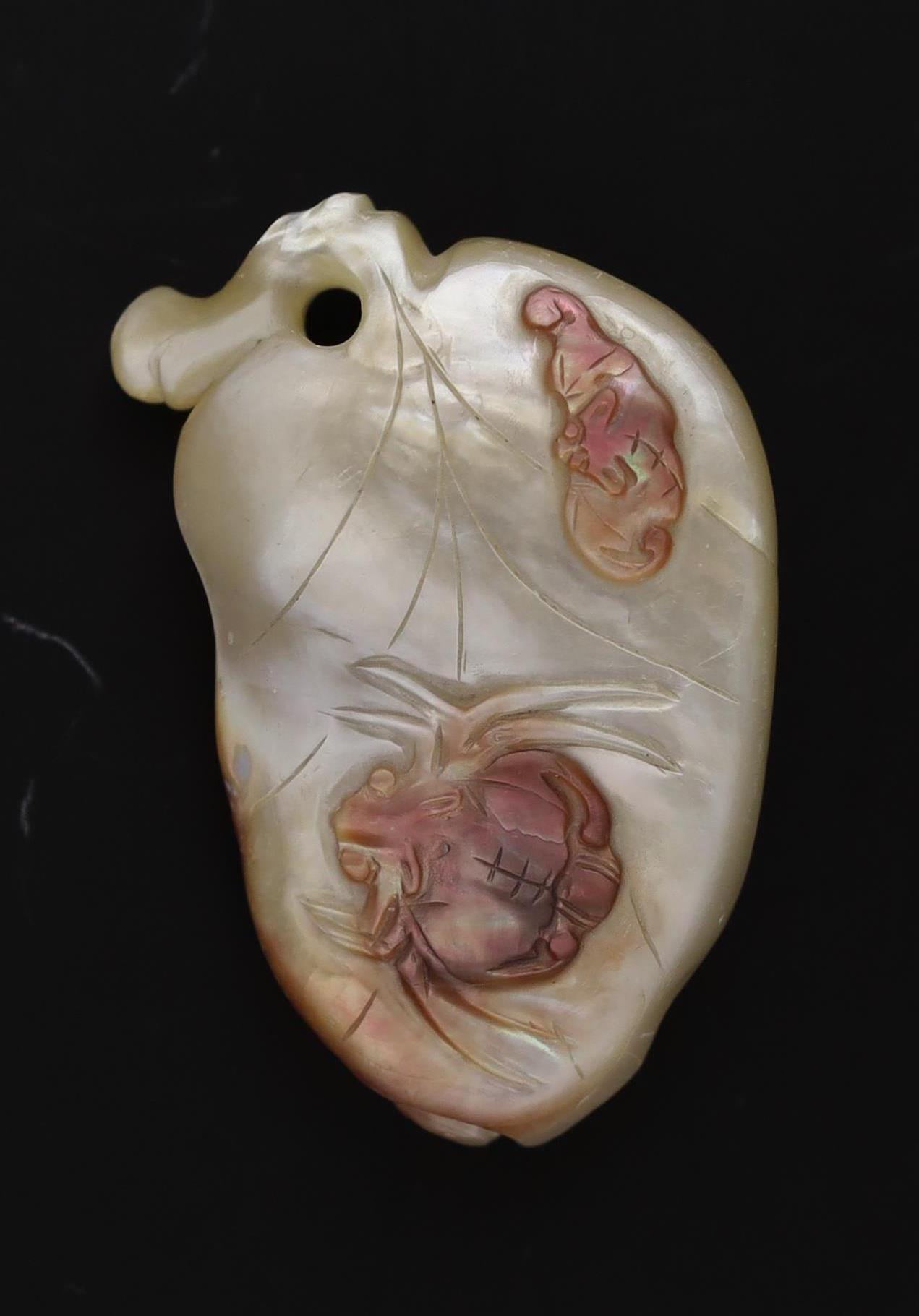 A Japanese mother of pearl netsuke of a leaf and berries, ridden by a bat and a spider, Meiji period
